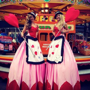 Stilt Walker in Queen of hearts Alice in Wonderland theme costumes at funfair